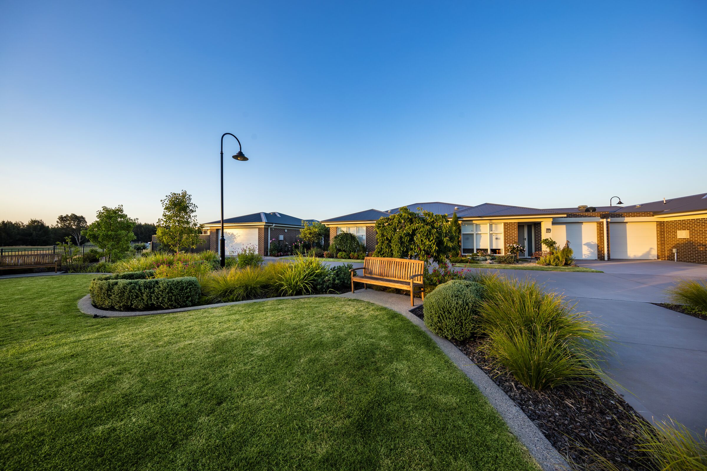 The Links at Waterford village roadway looking over common green area with seat towards houses