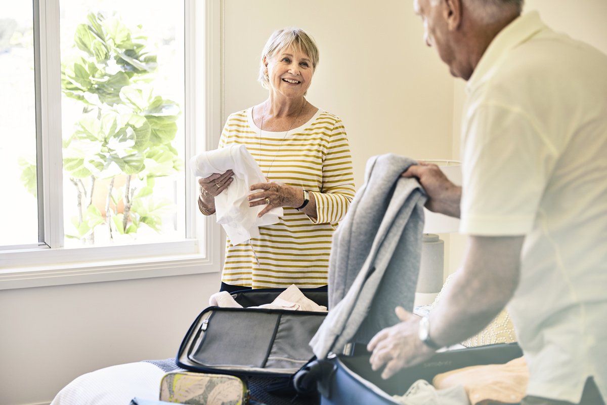 A senior couple packing their travel bag