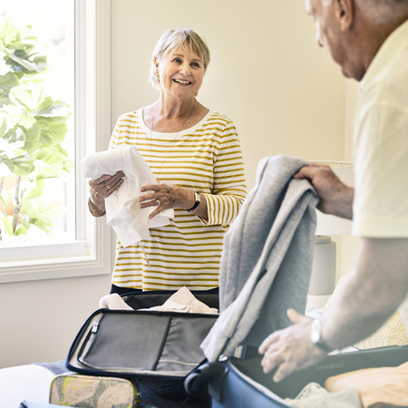 Two retirement village residents packing their luggage for a winter getaway