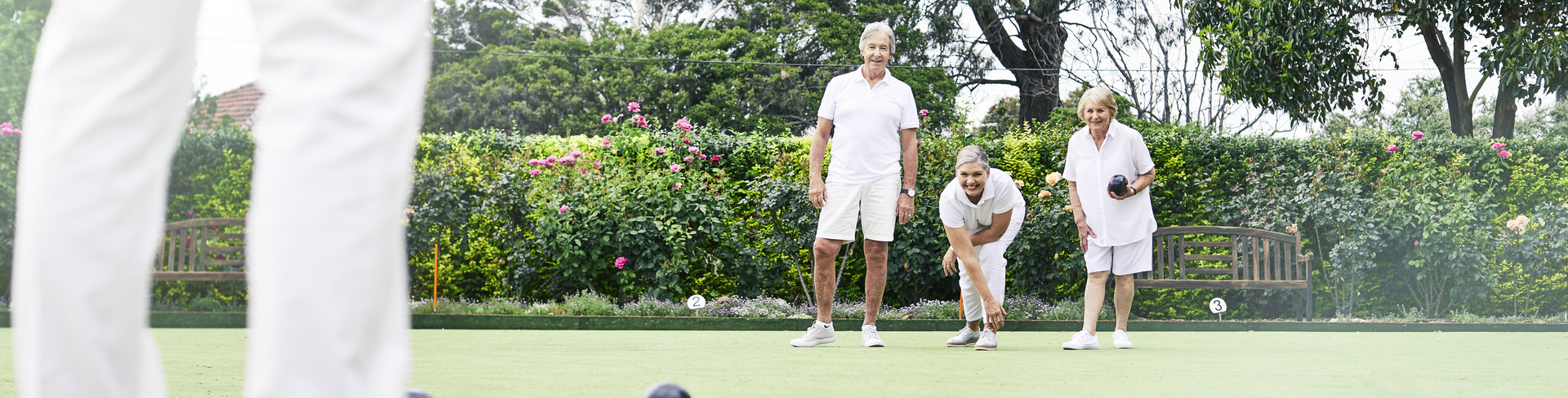 Male and female residents playing lawn bowls