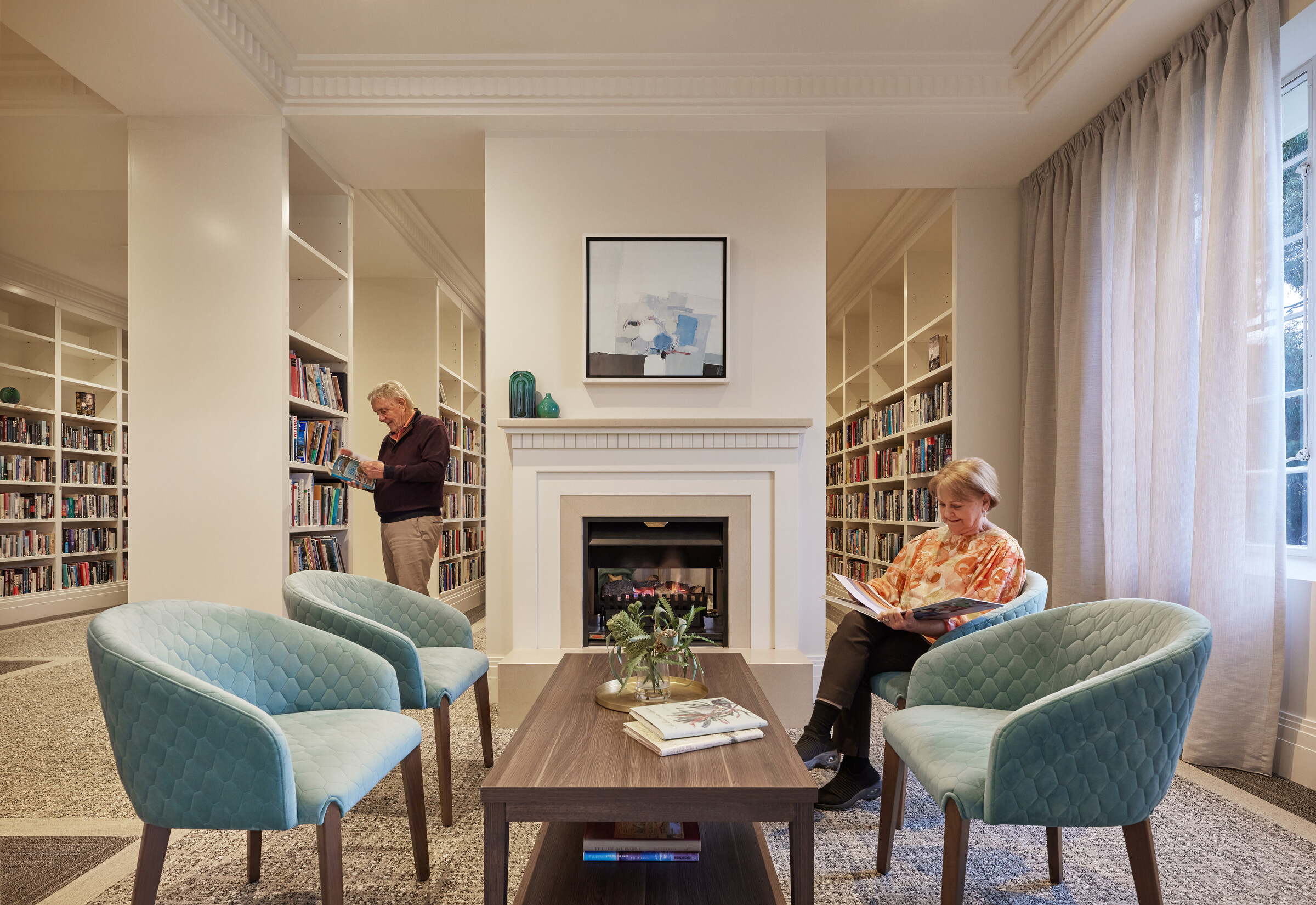 Classic Residences Brighton library room with fireplace, seating and well stocked bookcases