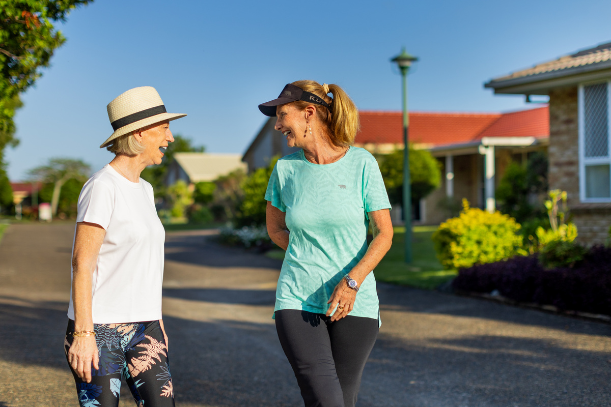 Two female residents of Hibiscus Chancellor Park walking through the retirement village