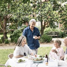 Senior friends having lunch in the garden on a sunny day