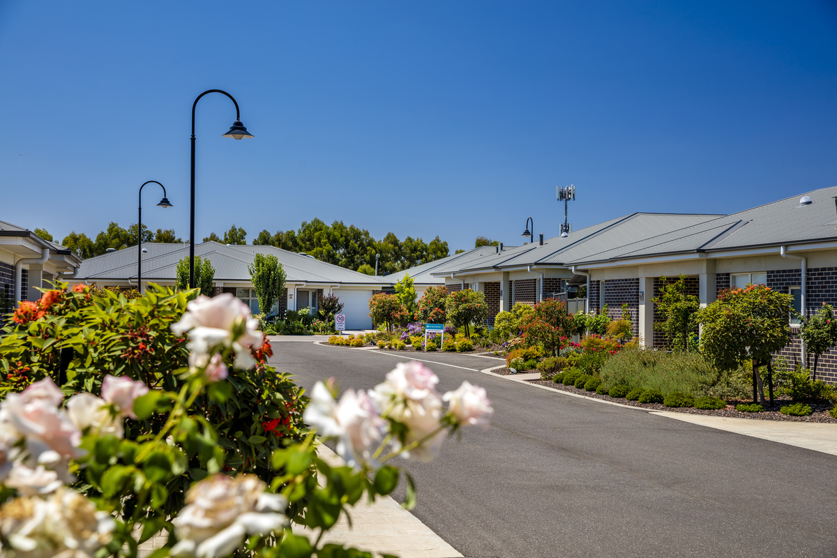The Links at Waterford village roadway with lamp posts, maintained gardens and brick houses