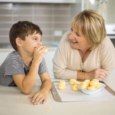 A woman and boy preparing food in kitchen