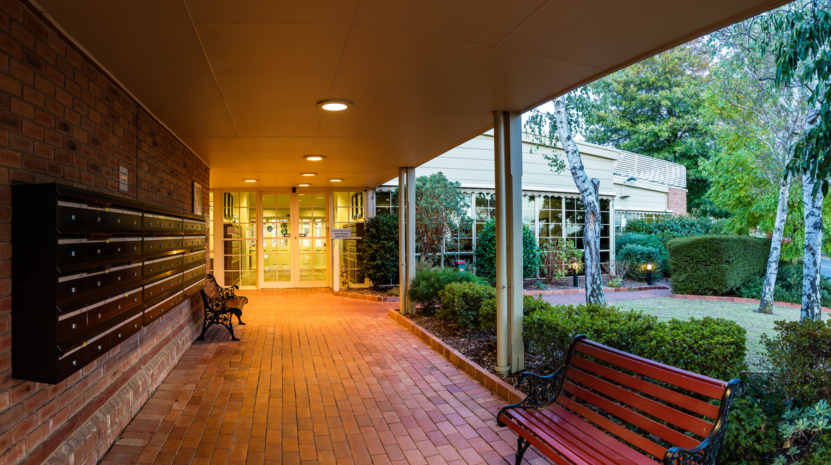 Fiddlers Green main entrance area, covered terrace area with seating and post boxes in the foreground