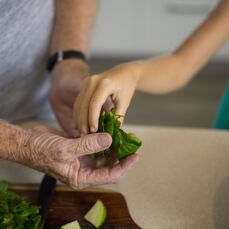 A man and girl preparing food in kitchen