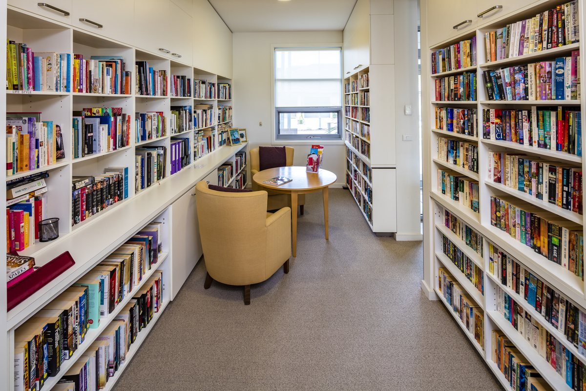 Caesia Gardens cozy library room with seating and well stocked bookcases