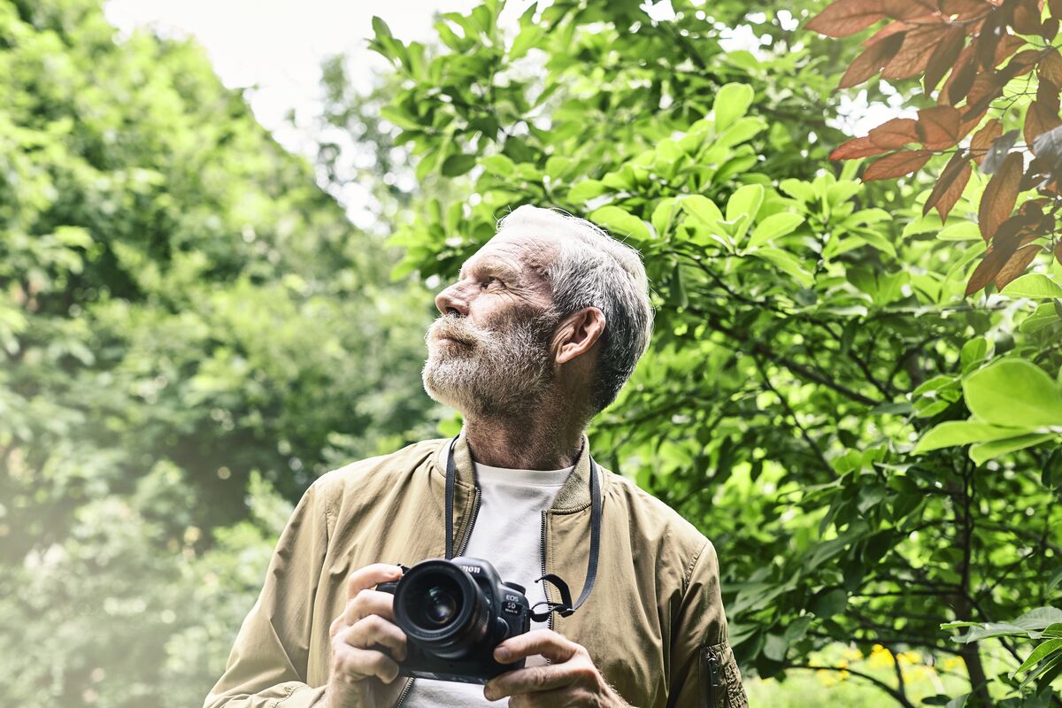Senior man with a camera in the outdoors
