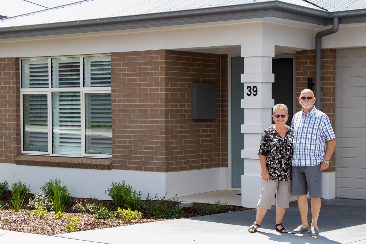 Senior Couple standing on the main entrance of The Aerie Village