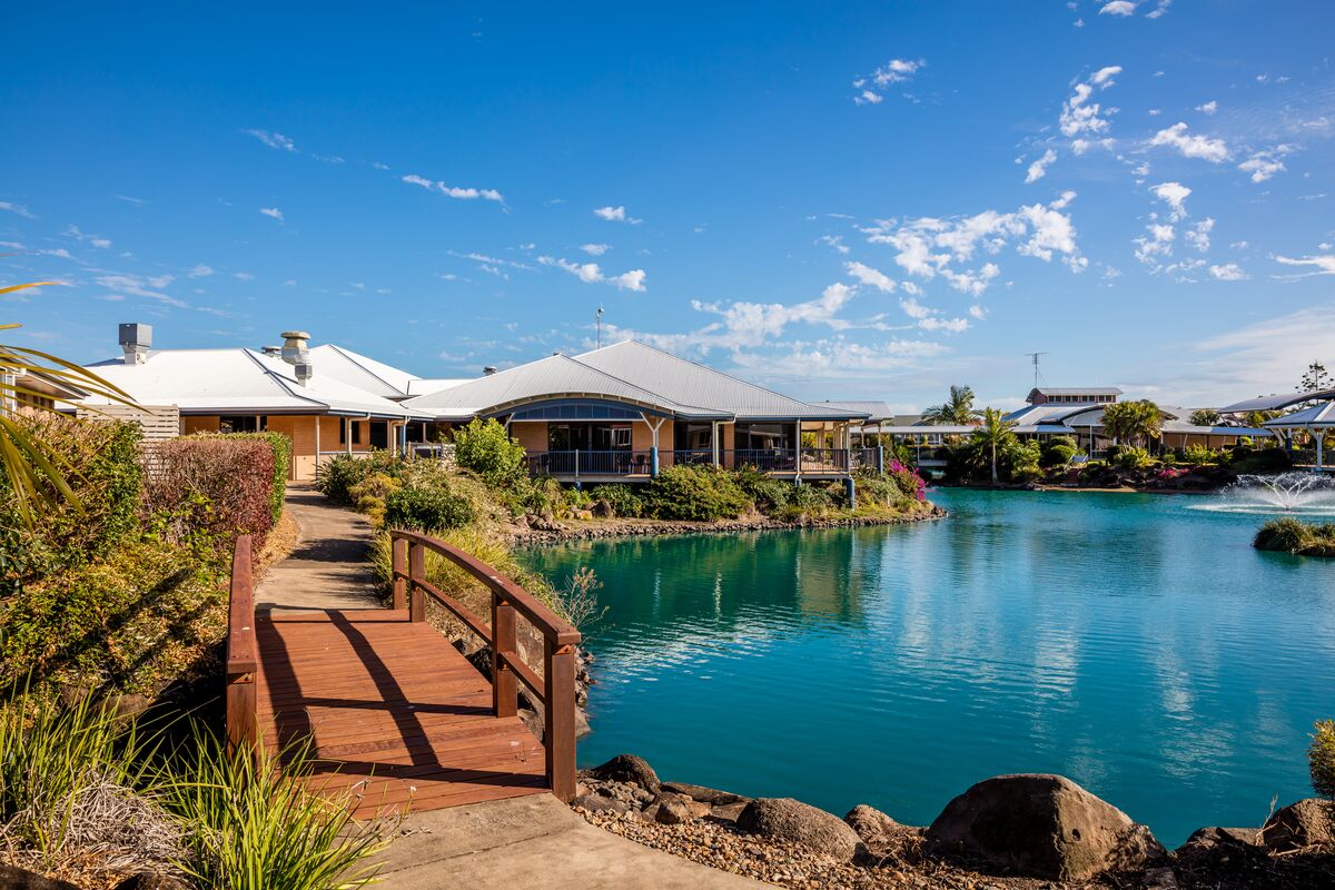 A bridge leading to villas next to a lake at The Lakes Bundaberg retirement village.