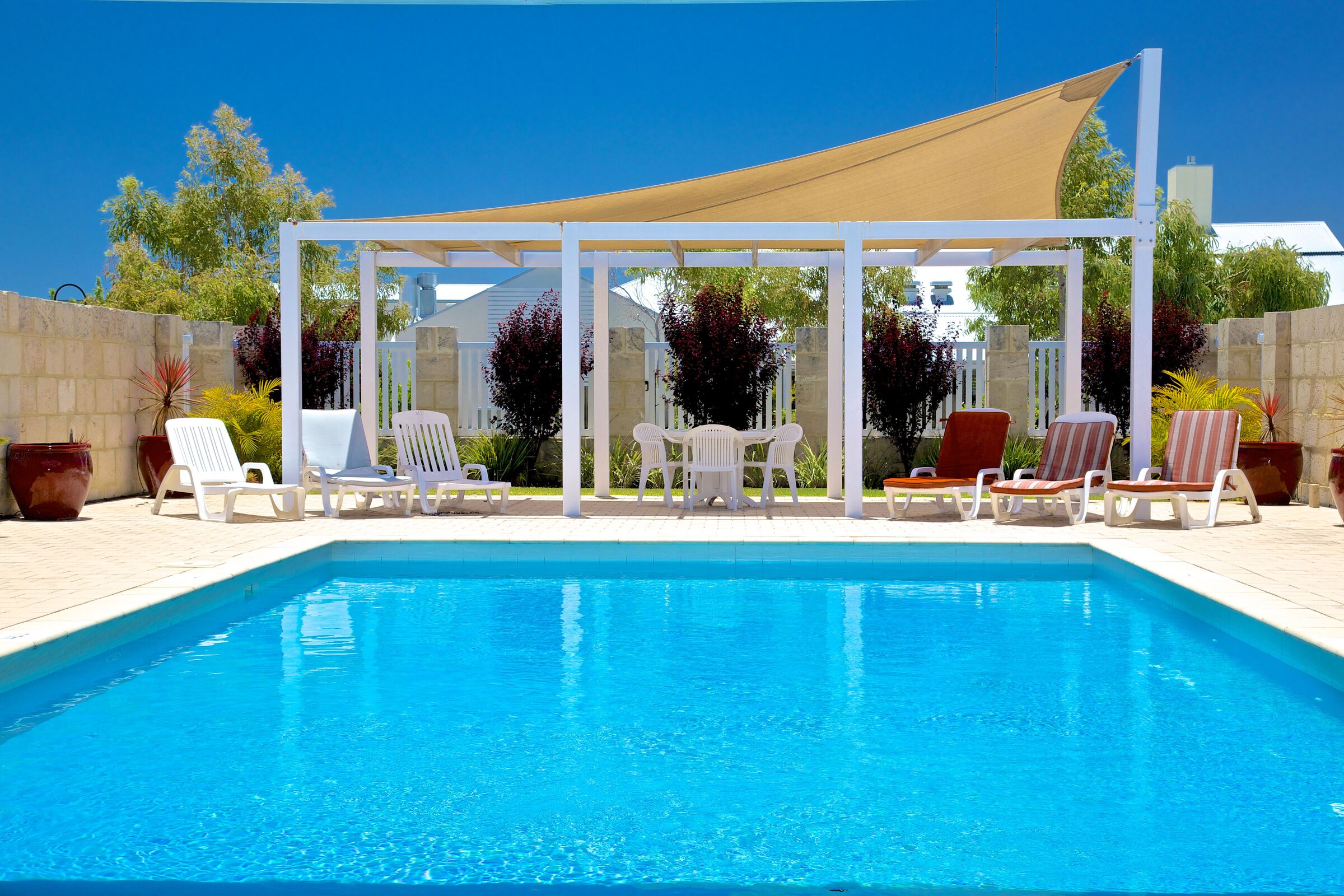 Parkland Villas Ellenbrook outdoor swimming pool with shaded poolside seating and pool lounges