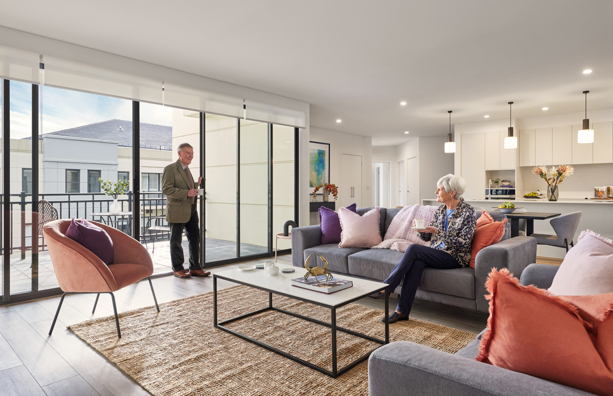 Menzies Malvern apartment living room with couple relaxing with beverages