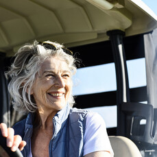 Senior woman on a golf cart smiling