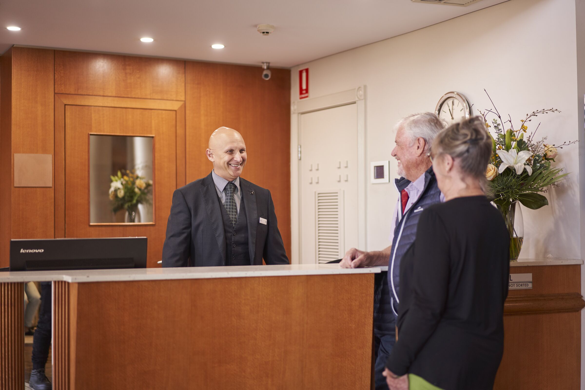 Senior couple talking to concierge at the resort reception