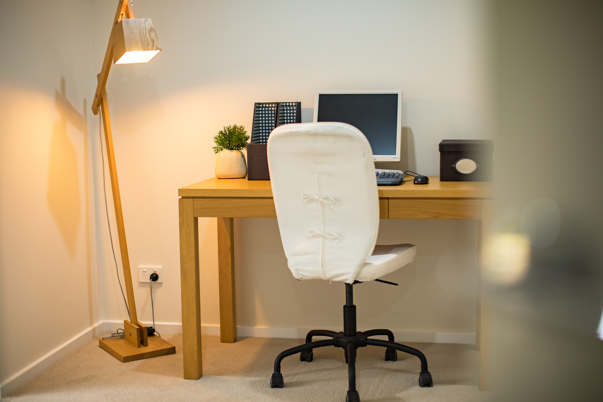 Meadowvale Village study area with desk, computer, chair and floor lamp